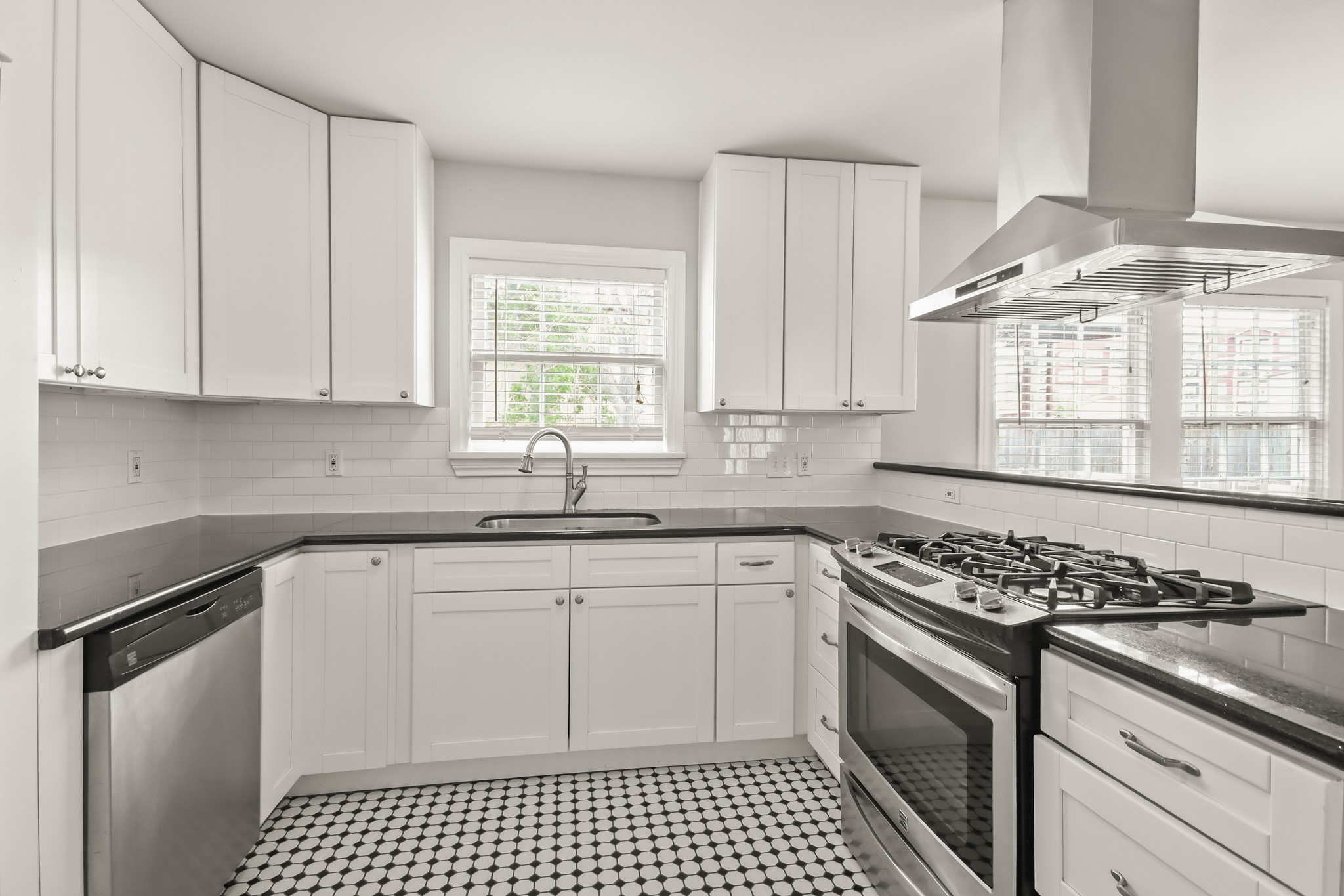 927 Walling Street Houston, TX 77009 - Photo 4 of 13 a kitchen with stainless steel appliances granite countertop a stove a sink and a white cabinets