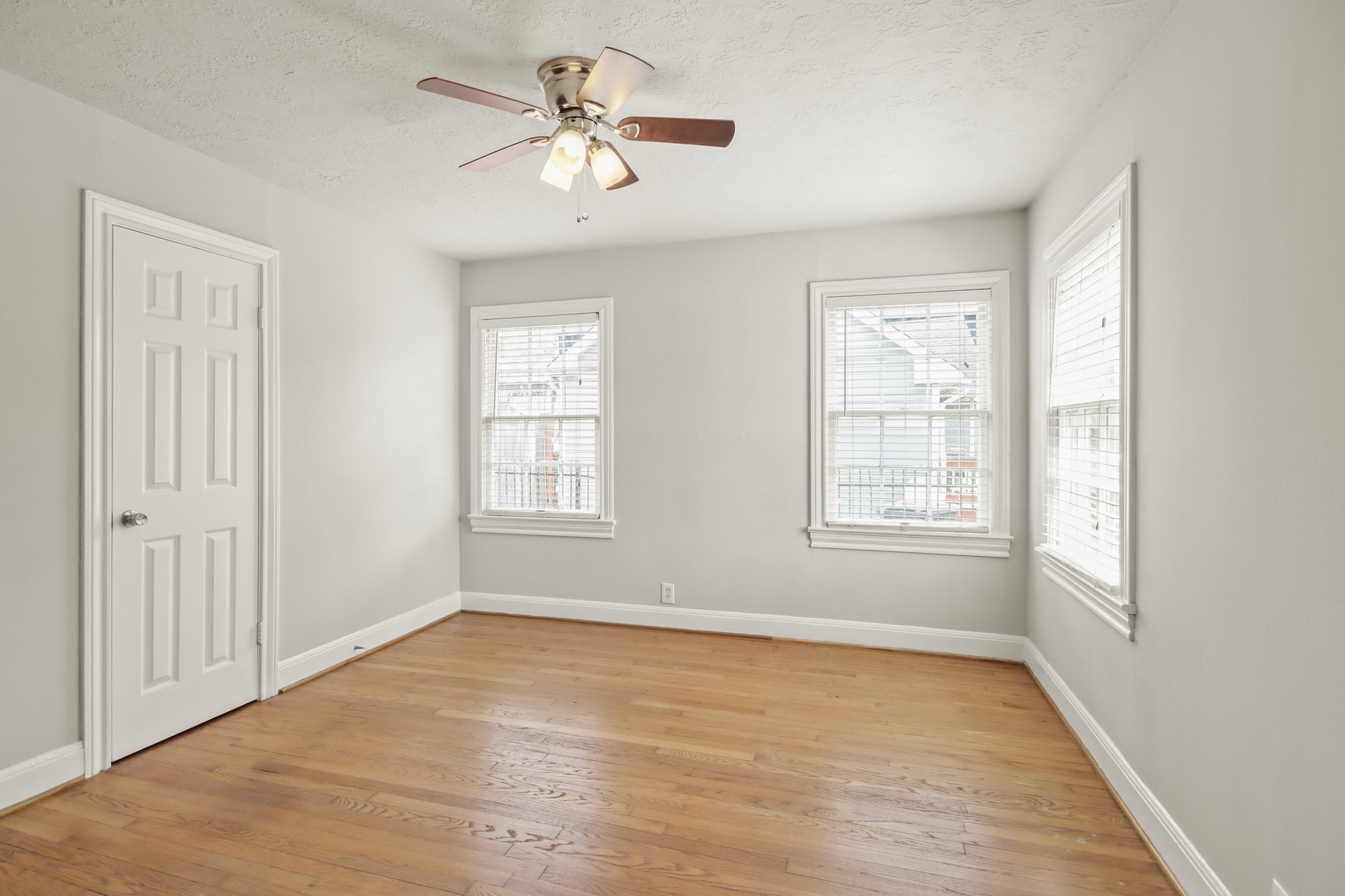 927 Walling Street Houston, TX 77009 - Photo 5 of 13 an empty room with wooden floor chandelier fan and windows