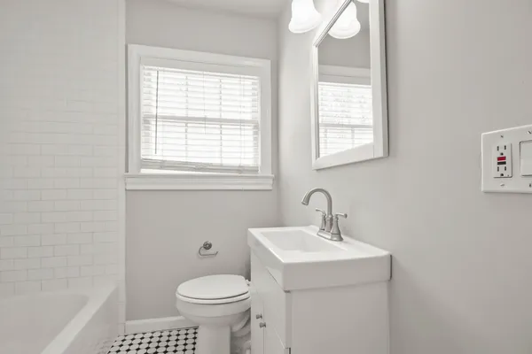 a bathroom with a sink a toilet and a window