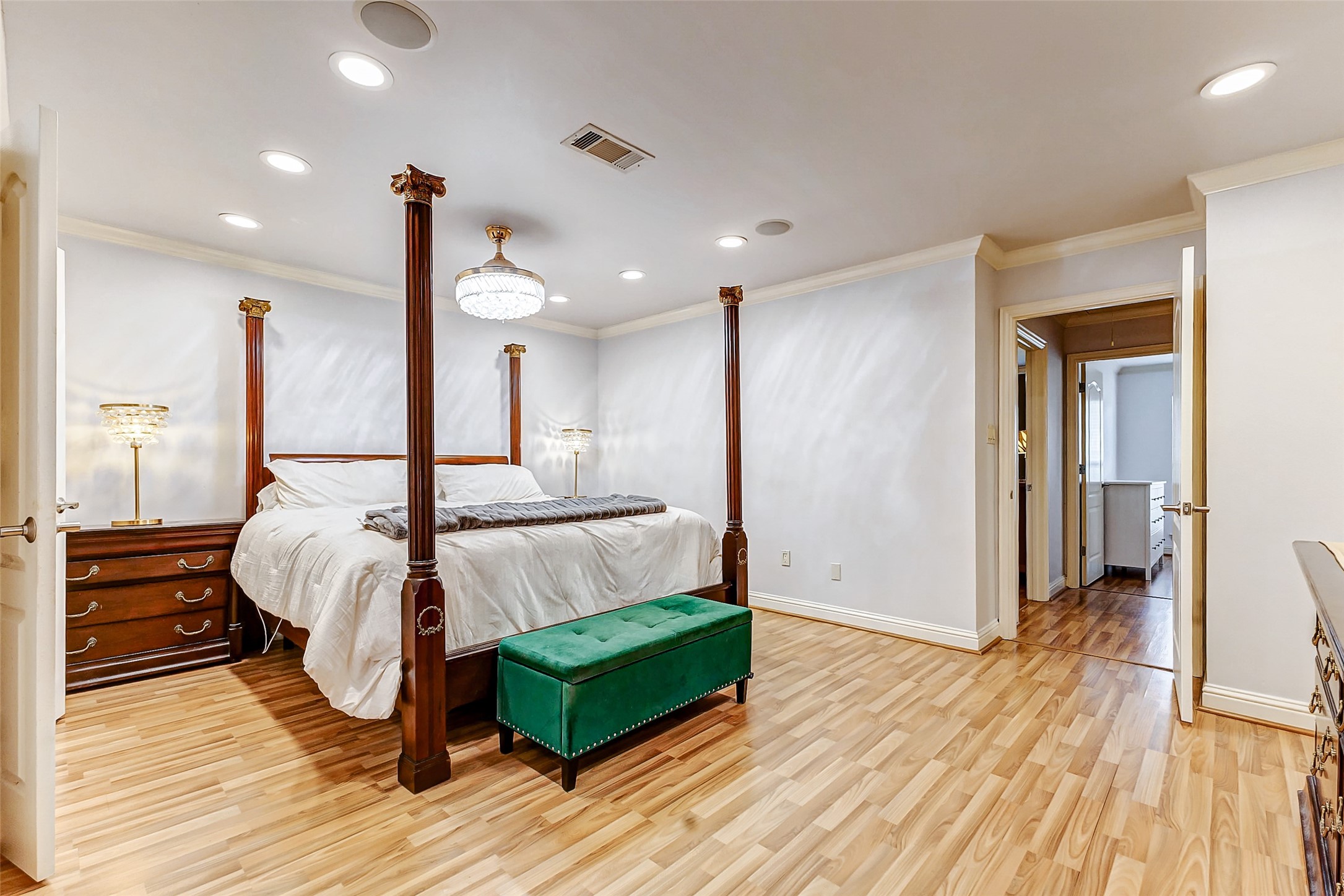 3022 Triway Lane Houston, TX 77043 - Photo 26 of 43 This expansive retreat offers enough space for both a sleeping area and a cozy sitting nook. A four-poster bed takes center stage, enhanced by a combination of recessed lighting and a semi-flush mounted fixture. Soft neutral tones create a calming ambiance, while the en suite bath adds to the room’s luxury.