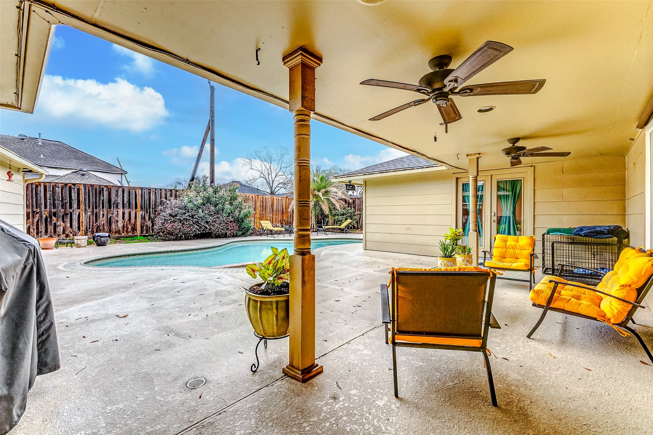 3022 Triway Lane Houston, TX 77043 - Photo 37 of 43 This spacious covered patio offers plenty of room for a large seating arrangement or an outdoor dining setup. Twin ceiling fans provide a refreshing breeze, making it an ideal spot to relax or gather while enjoying the nearby pool.