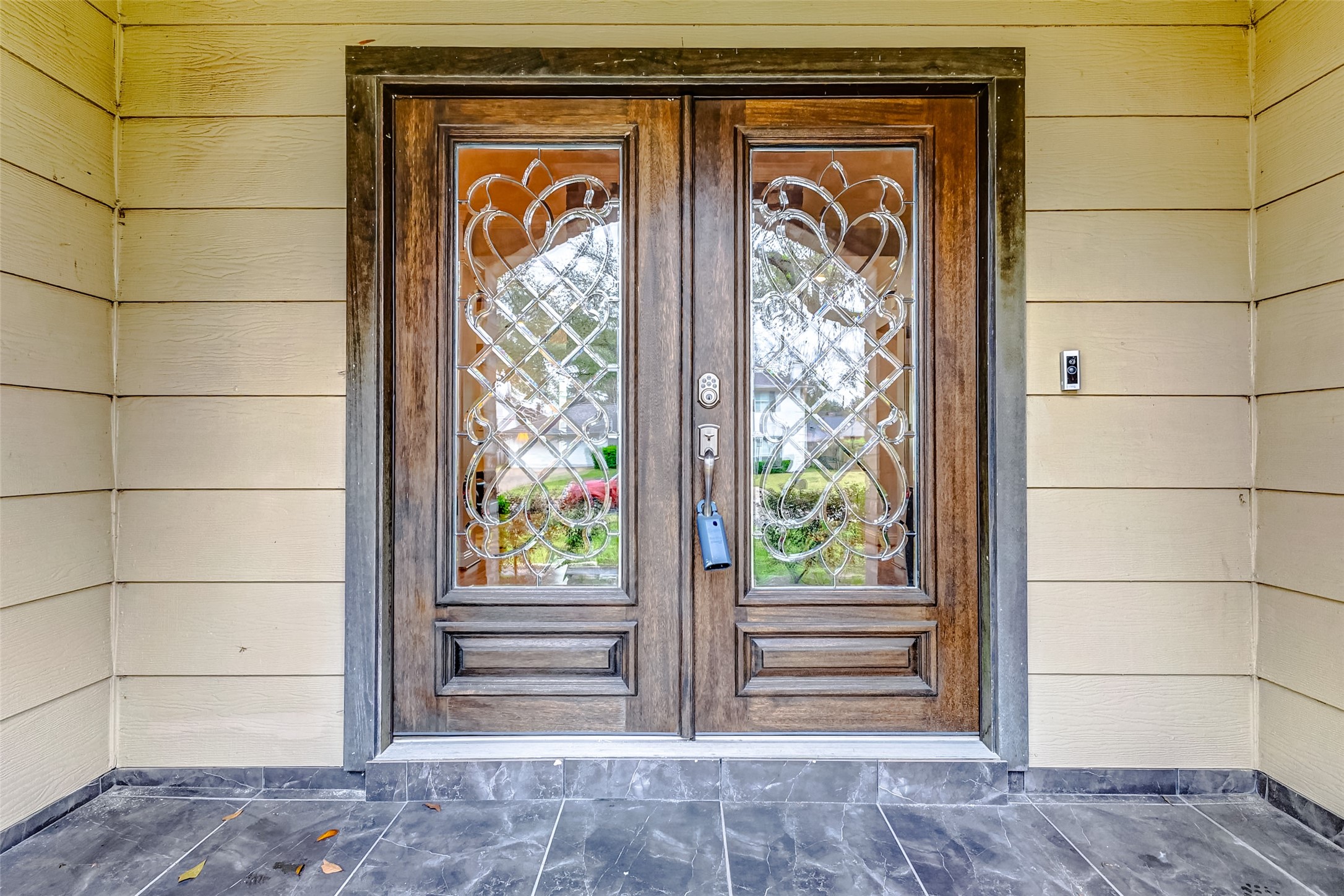3022 Triway Lane Houston, TX 77043 - Photo 4 of 43 Rich wood double doors, adorned with leaded glass panels, create an inviting yet sophisticated entrance. The covered entryway offers shelter and an elegant transition into the home.