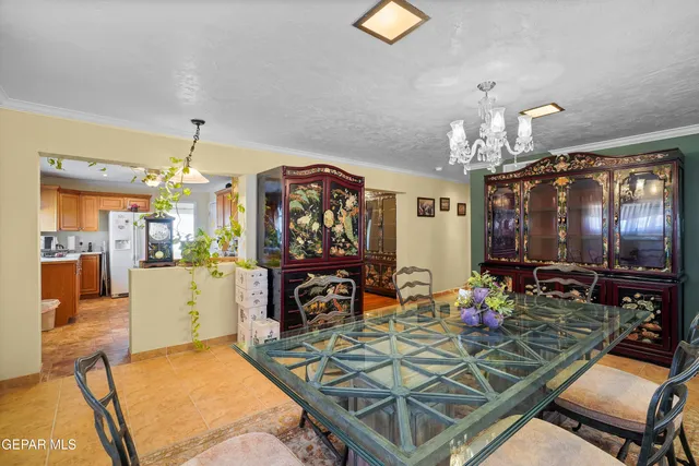 a living room with dining table and a chandelier
