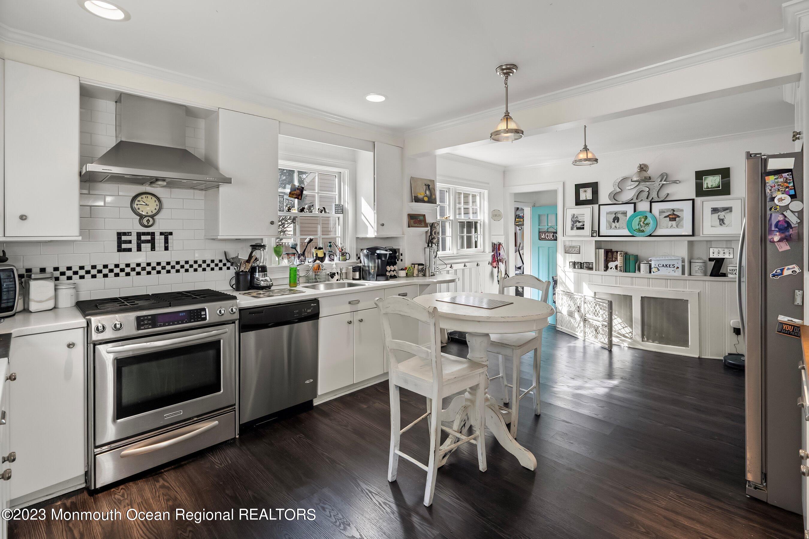 24 St Nicholas Place Red Bank, NJ 07701 - Photo 3 of 11 a kitchen with stainless steel appliances a white stove top oven a sink dishwasher and white cabinets with wooden floor