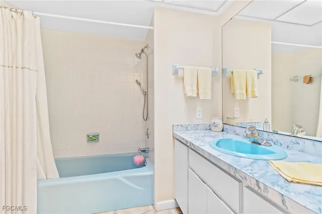a bathroom with a granite countertop tub sink and mirror