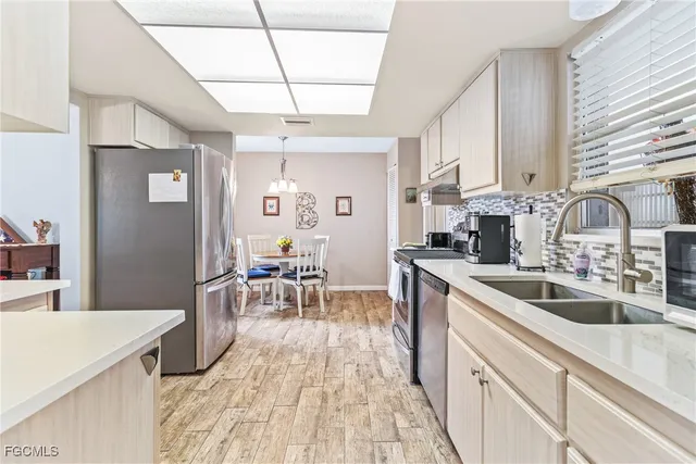 a kitchen with stainless steel appliances granite countertop a sink stove and cabinets