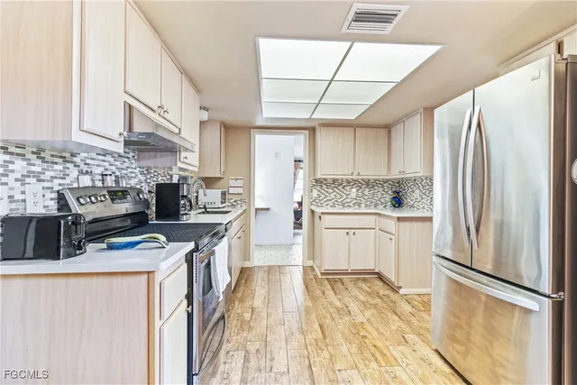 a kitchen with stainless steel appliances a refrigerator sink and cabinets