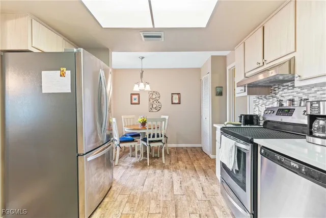 a kitchen with stainless steel appliances granite countertop a stove and a refrigerator
