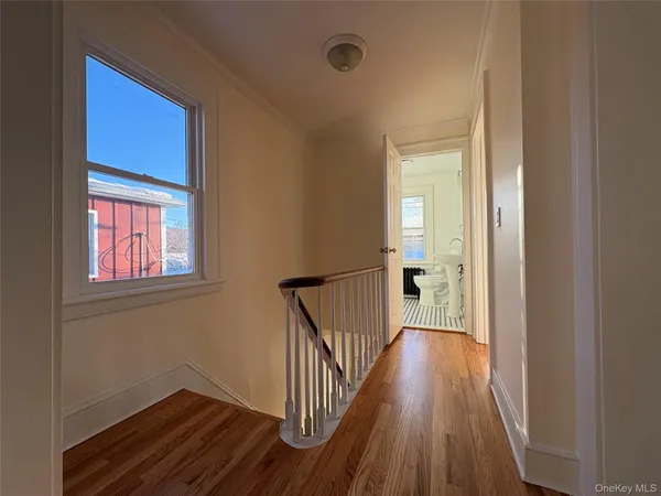 a view of a hallway with wooden floor and a window