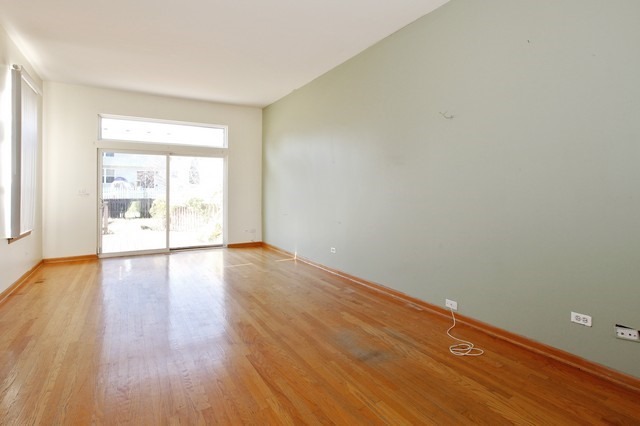 2213 Carpenter Avenue Plainfield, IL 60586 - Photo 4 of 25 a view of an empty room with wooden floor and a window