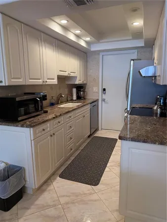 a kitchen with stainless steel appliances granite countertop a sink stove and cabinets