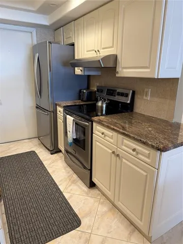 a kitchen with stainless steel appliances granite countertop a stove a refrigerator and a sink