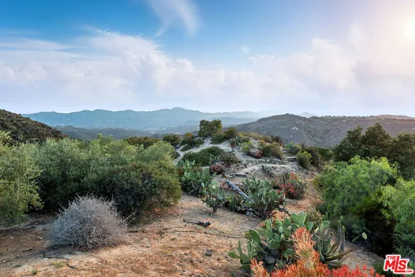 a view of a lake in middle of a field