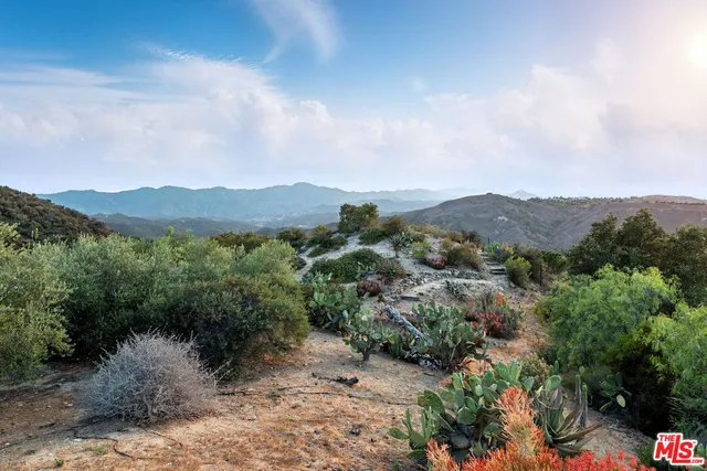 a view of a lake in middle of a field