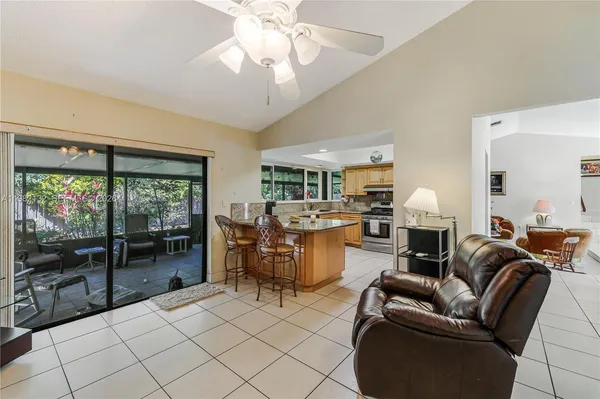 a living room with furniture a flat screen tv and a floor to ceiling window