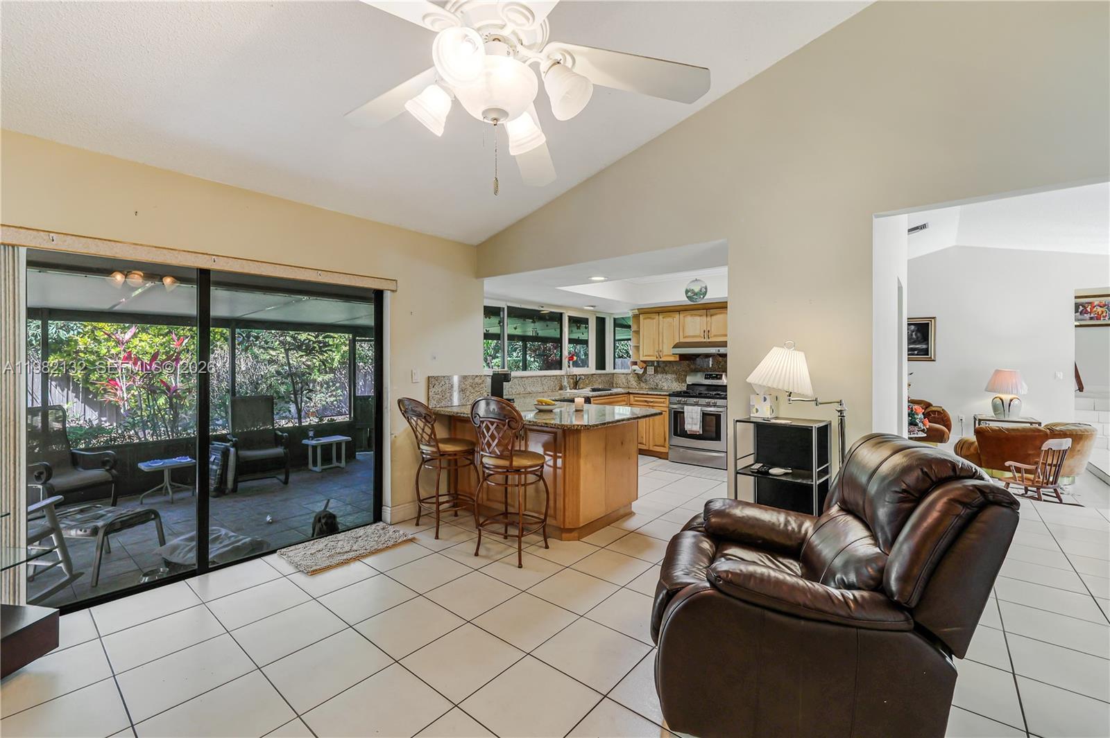 11541 Southwest 100th Street Miami, FL 33176 - Photo 18 of 51 a living room with furniture a flat screen tv and a floor to ceiling window