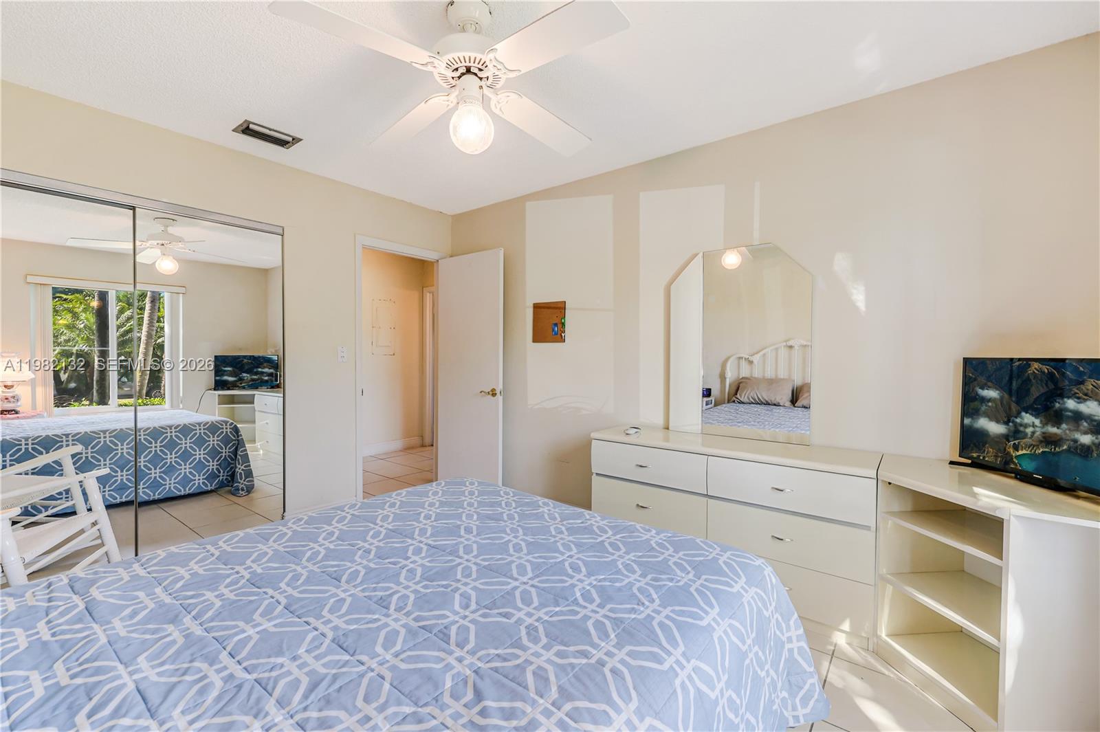 11541 Southwest 100th Street Miami, FL 33176 - Photo 28 of 51 a bedroom with a bed and a chandelier