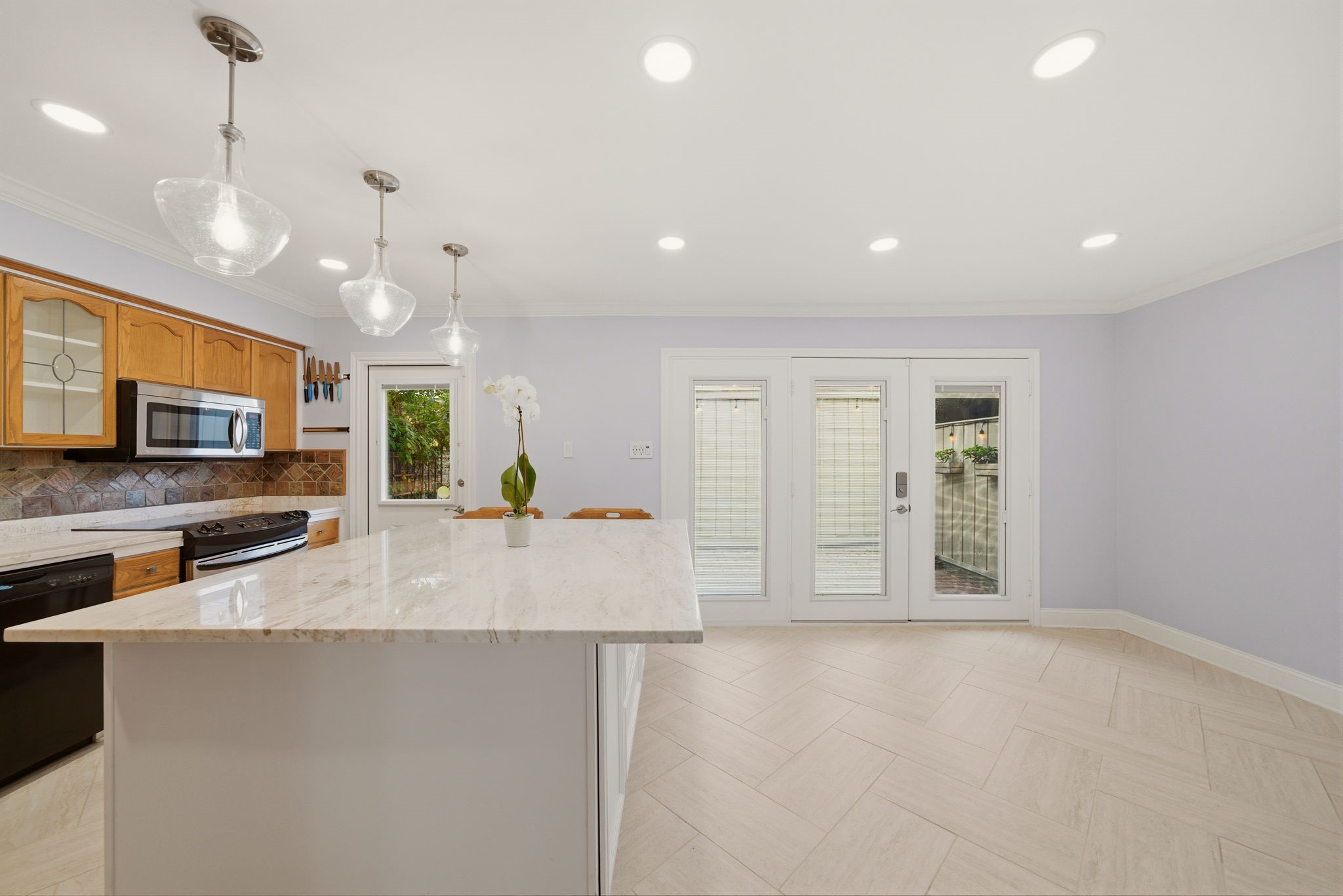 6452 Burgoyne Road, Unit 100 Houston, TX 77057 - Photo 10 of 44 a view of a kitchen with kitchen island a sink stainless steel appliances and a counter top space