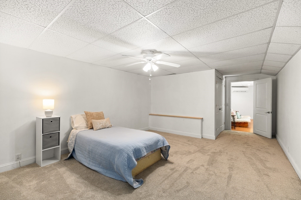 32 Witham Street, Unit B Gloucester, MA 01930 - Photo 27 of 36 a spacious bedroom with a bed and a chandelier