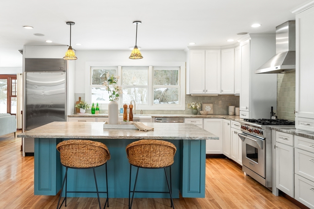 32 Witham Street, Unit B Gloucester, MA 01930 - Photo 6 of 36 a kitchen with stainless steel appliances a dining table chairs and wooden floor