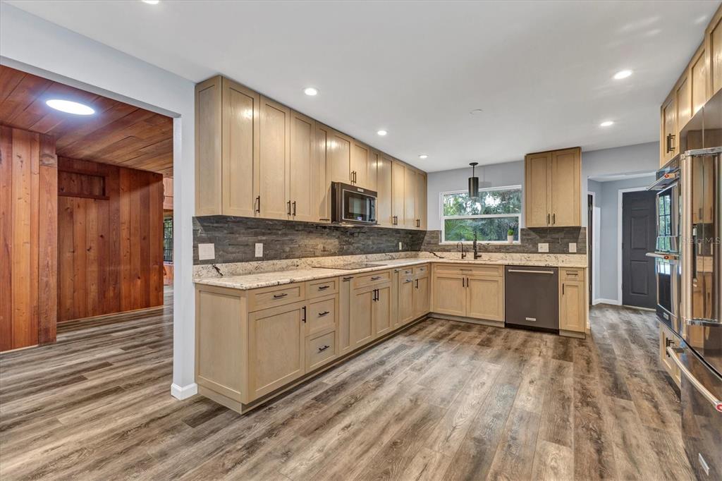 2308 Shadow Oaks Road Sarasota, FL 34240 - Photo 16 of 84 a kitchen with granite countertop a sink cabinets stainless steel appliances and a counter top space