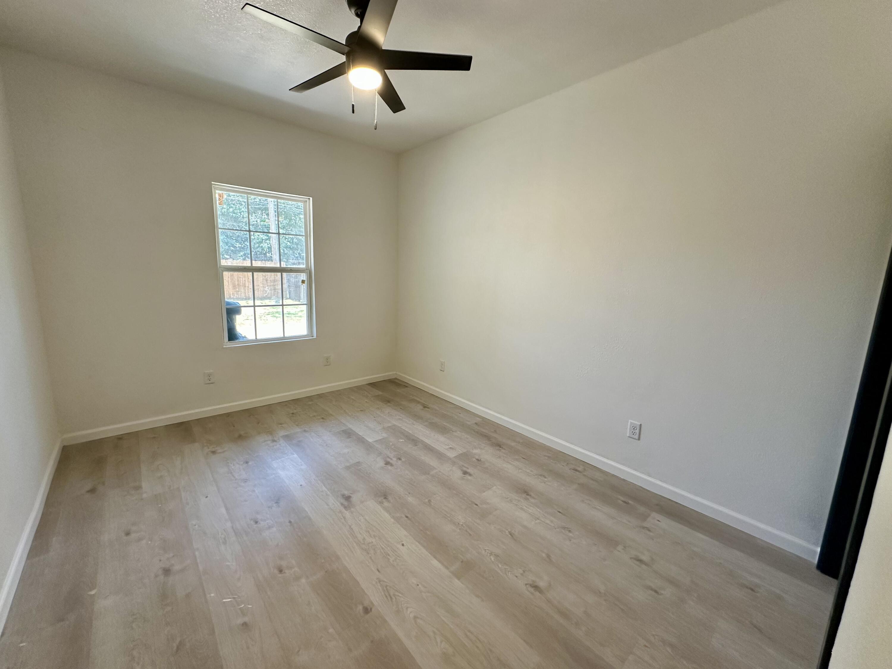 4709 47th Street Lubbock, TX 79414 - Photo 6 of 12 wooden floor in an empty room with a window