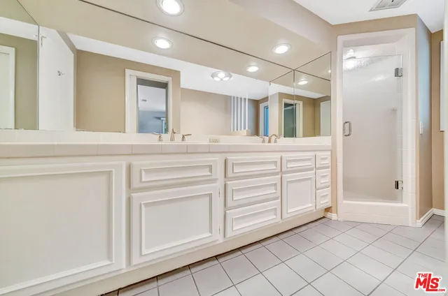 a bathroom with a sink a mirror and a shower