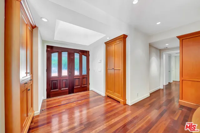 a view of a hallway with wooden floor and furniture