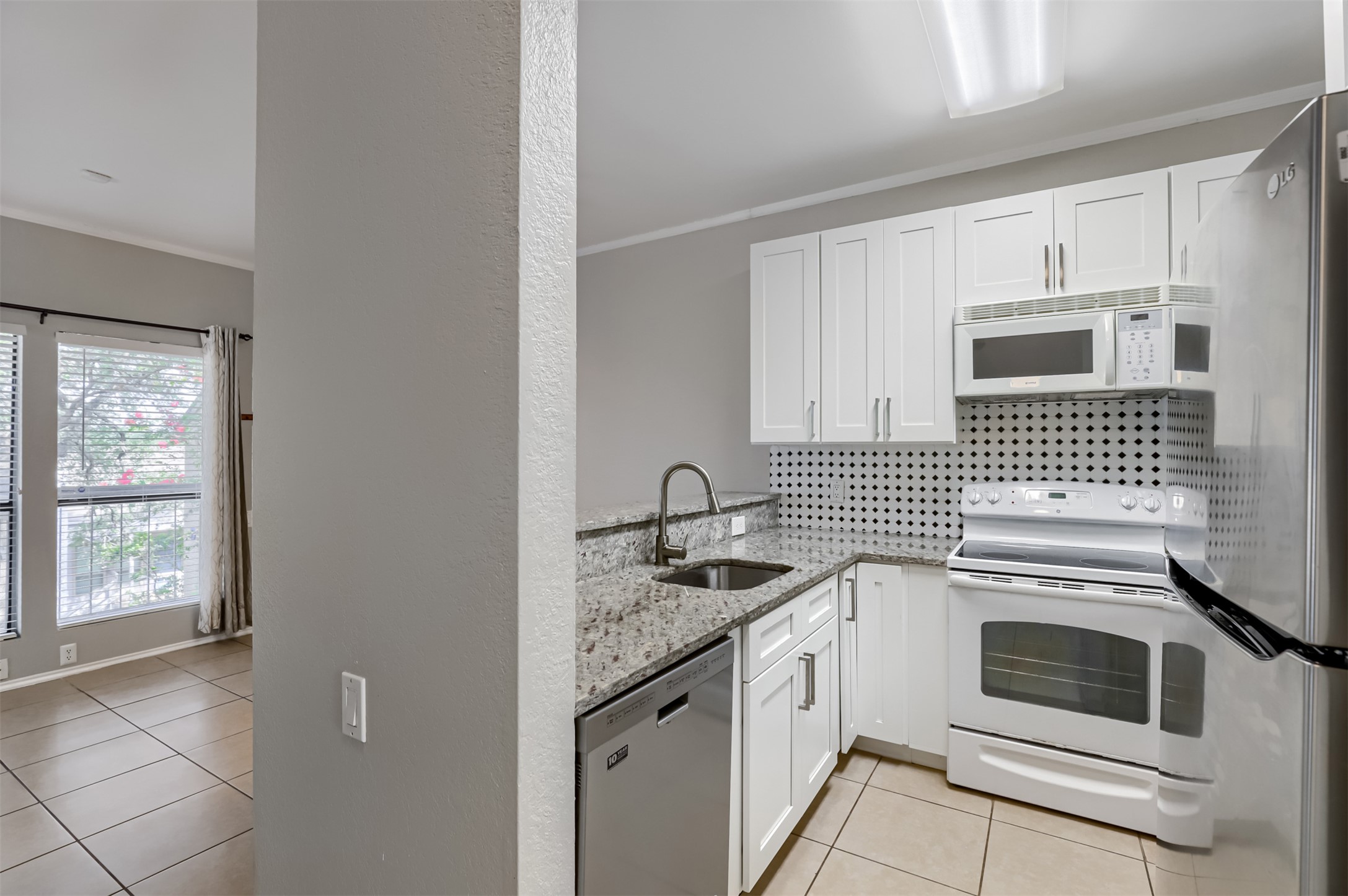 802 South 1st Street, Unit 206 Austin, TX 78704 - Photo 4 of 18 a kitchen with granite countertop white cabinets and white appliances