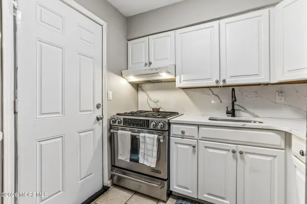 a kitchen with white cabinets and white appliances