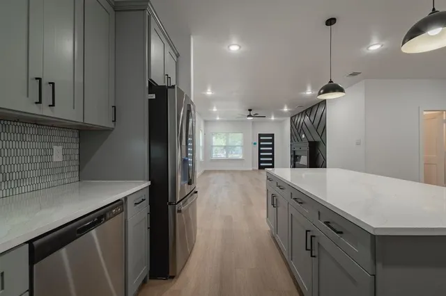 a kitchen with stainless steel appliances granite countertop a sink and a refrigerator