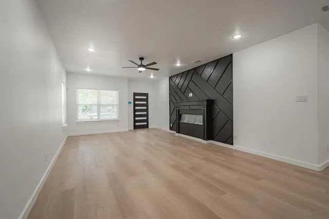 a view of an empty room with a fireplace and a window