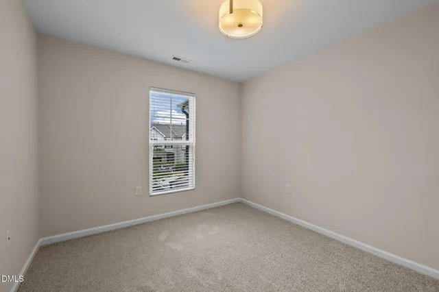 an empty room with chandelier fan