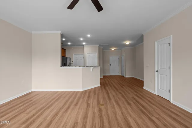 a view of empty room with wooden floor and window