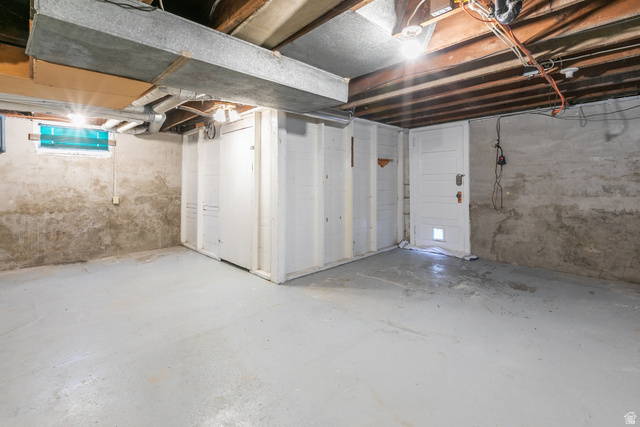 59 East Pinehurst Street Tooele, UT 84074 - Photo 16 of 22 Unfinished basement space featuring exposed ceiling joists, painted concrete flooring, and a small window