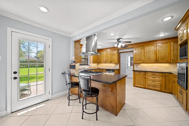 a kitchen with stainless steel appliances granite countertop a stove a sink and a refrigerator
