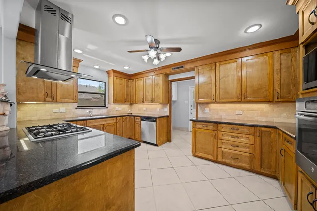 a kitchen with stainless steel appliances granite countertop a stove sink and cabinets
