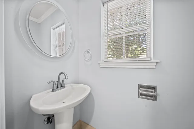 a bathroom with a sink a mirror and a window
