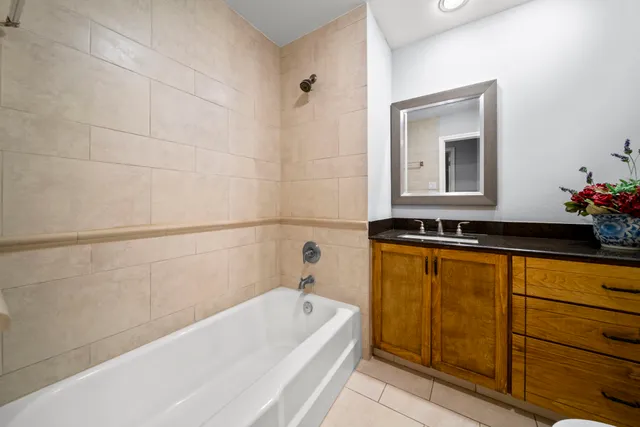 a bathroom with a tub sink and mirror