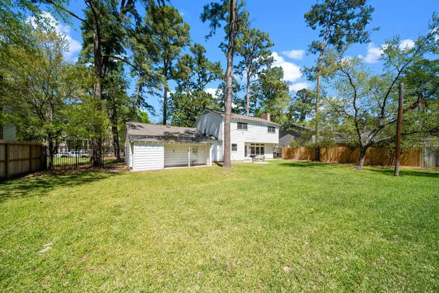 a view of a house with a yard and tree s