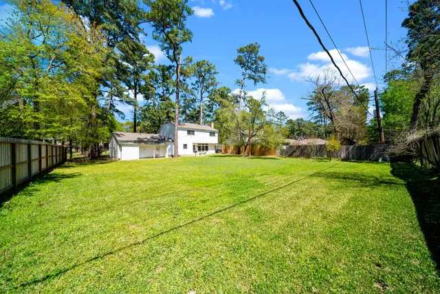 a view of house with backyard and trees