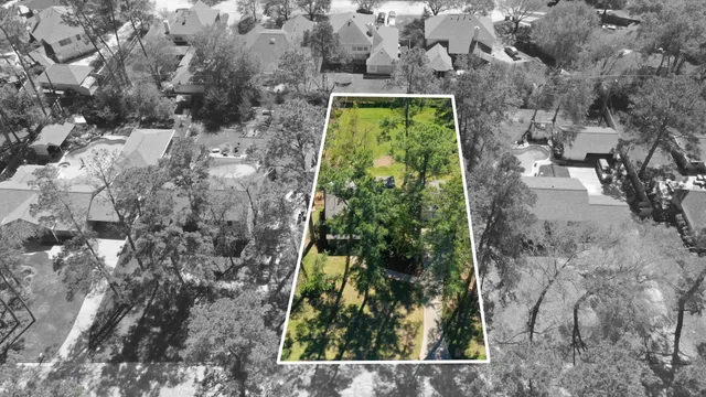 an aerial view of a house with a yard and large trees