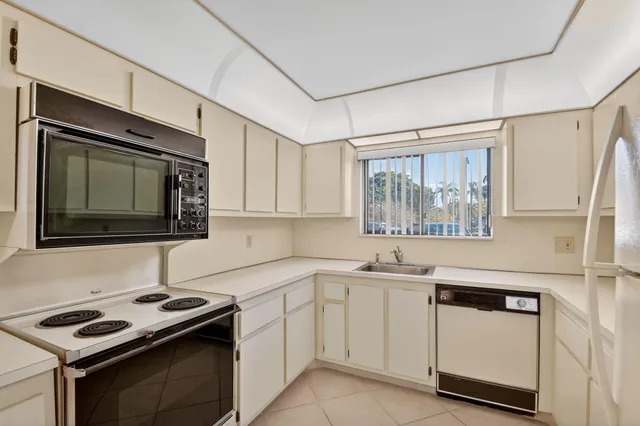 a kitchen with white cabinets and a stove top oven