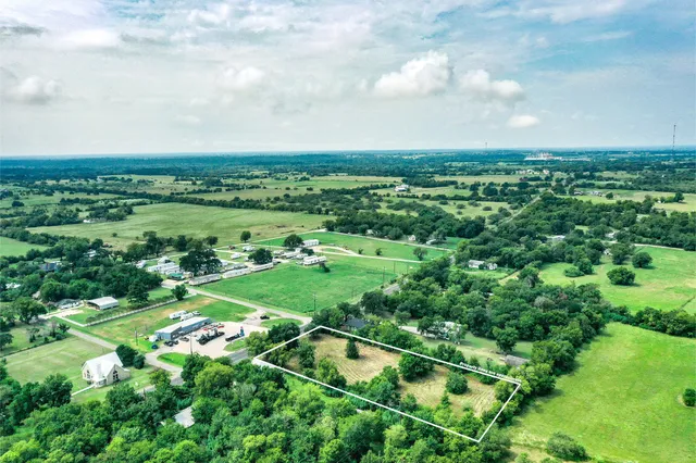 an aerial view of a house with a yard and greenery