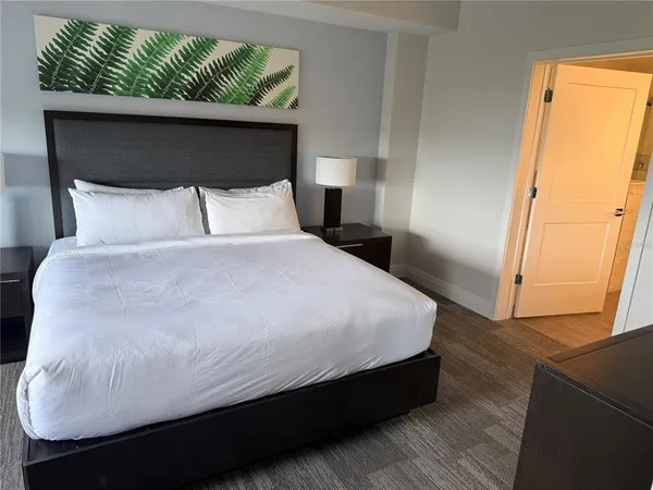 a large bed sitting in a bedroom next to a window