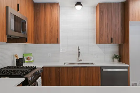 a kitchen with a sink a stove and cabinets