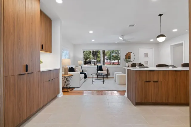a living room with furniture a large window and potted plants