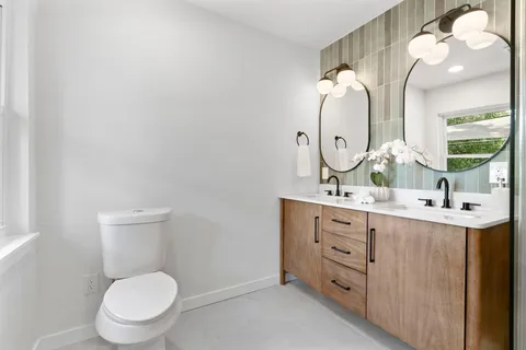 a bathroom with a toilet sink and mirror