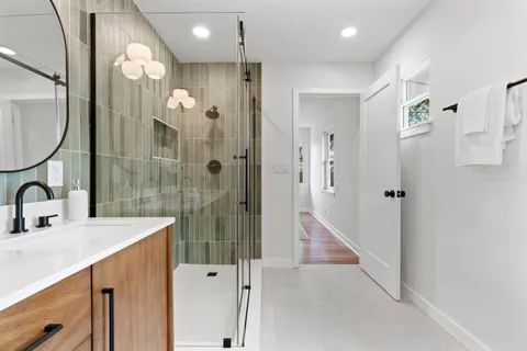 a bathroom with a sink a toilet and shower