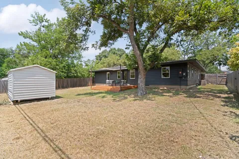 a backyard of a house with white floor and tree